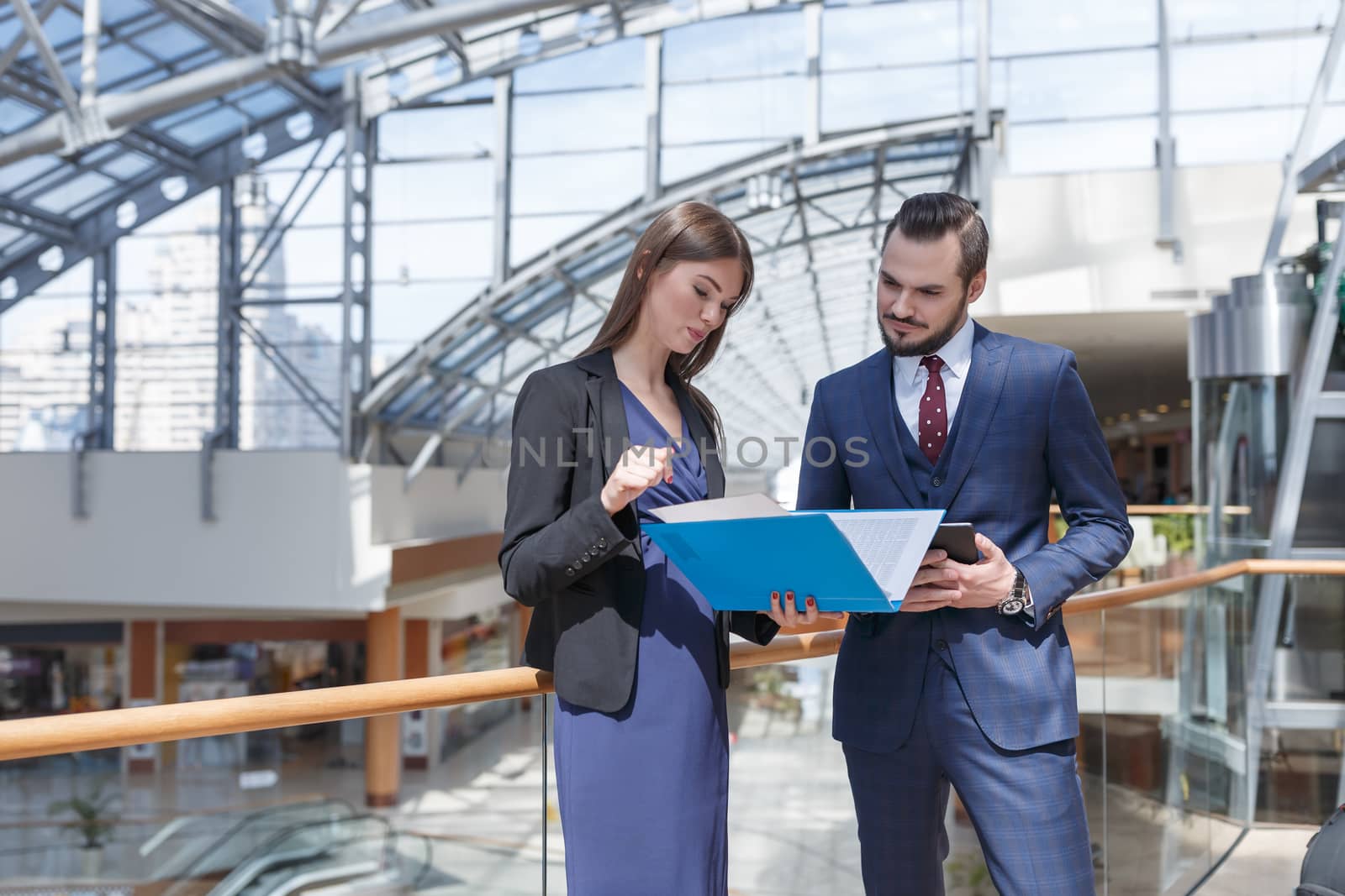 Business partners talking and looking at documents at business center