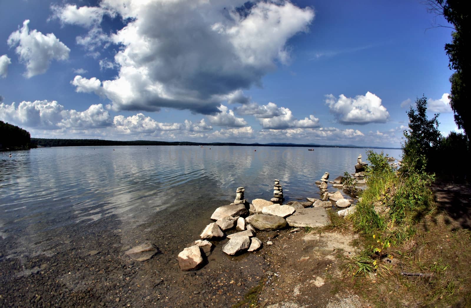 morning on the lake with clear water, you can see the rocky bottom,on the shore of stone pyramids