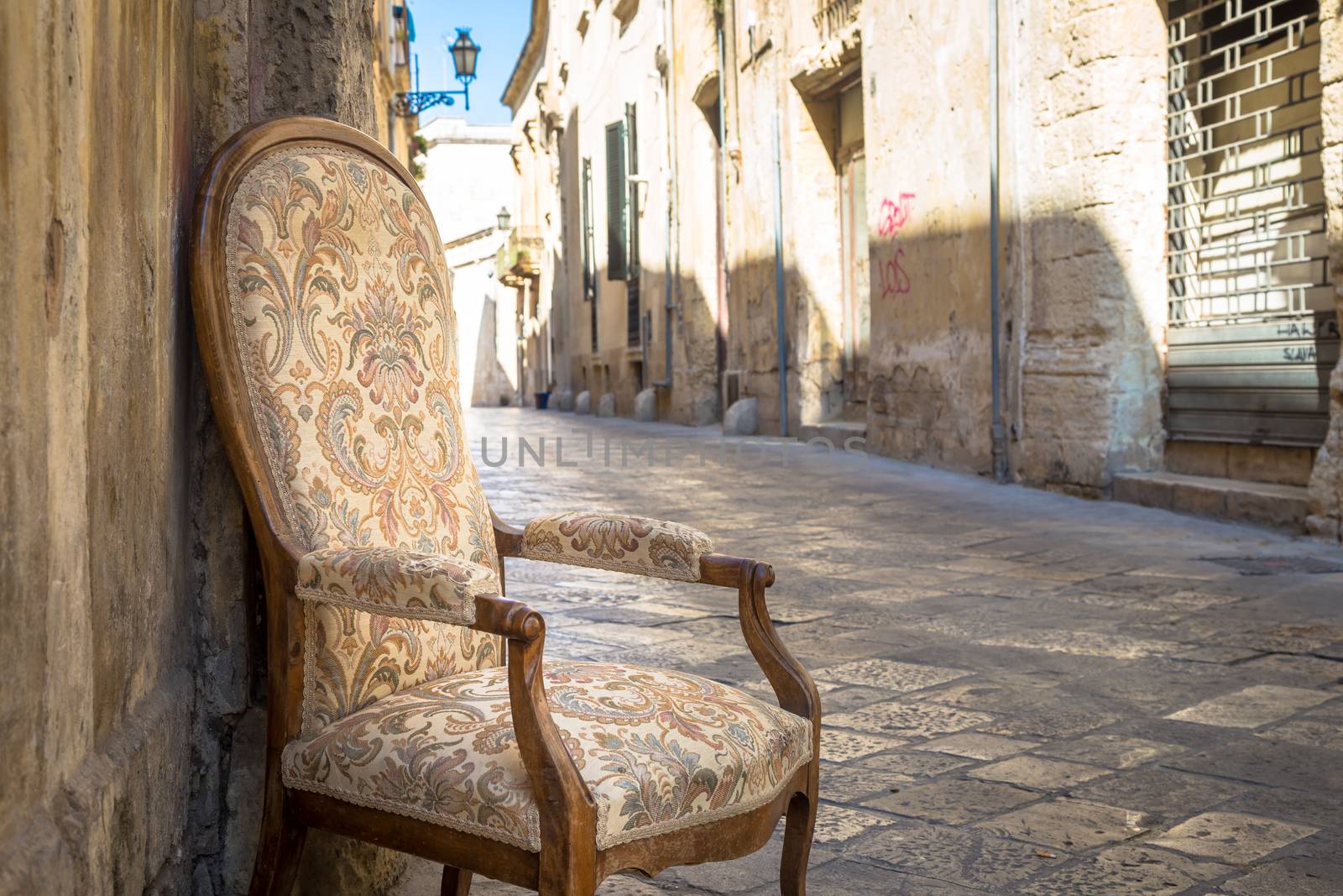 Lecce town, Italy. Vintage chair with old town street in background.