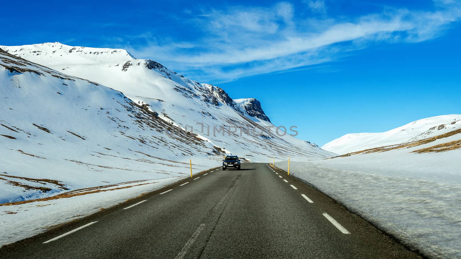 A long straight road and cars in winter. 