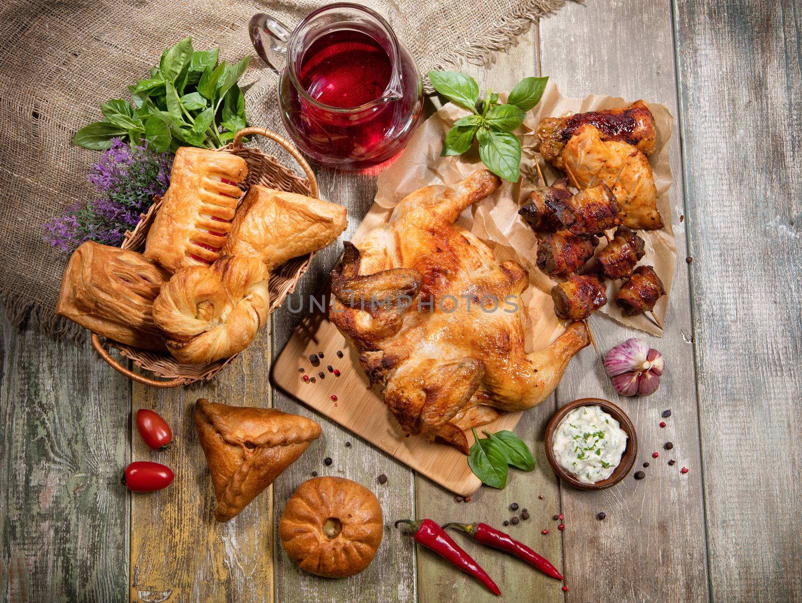 Roasted chicken, juice and bakery on an old wooen desk