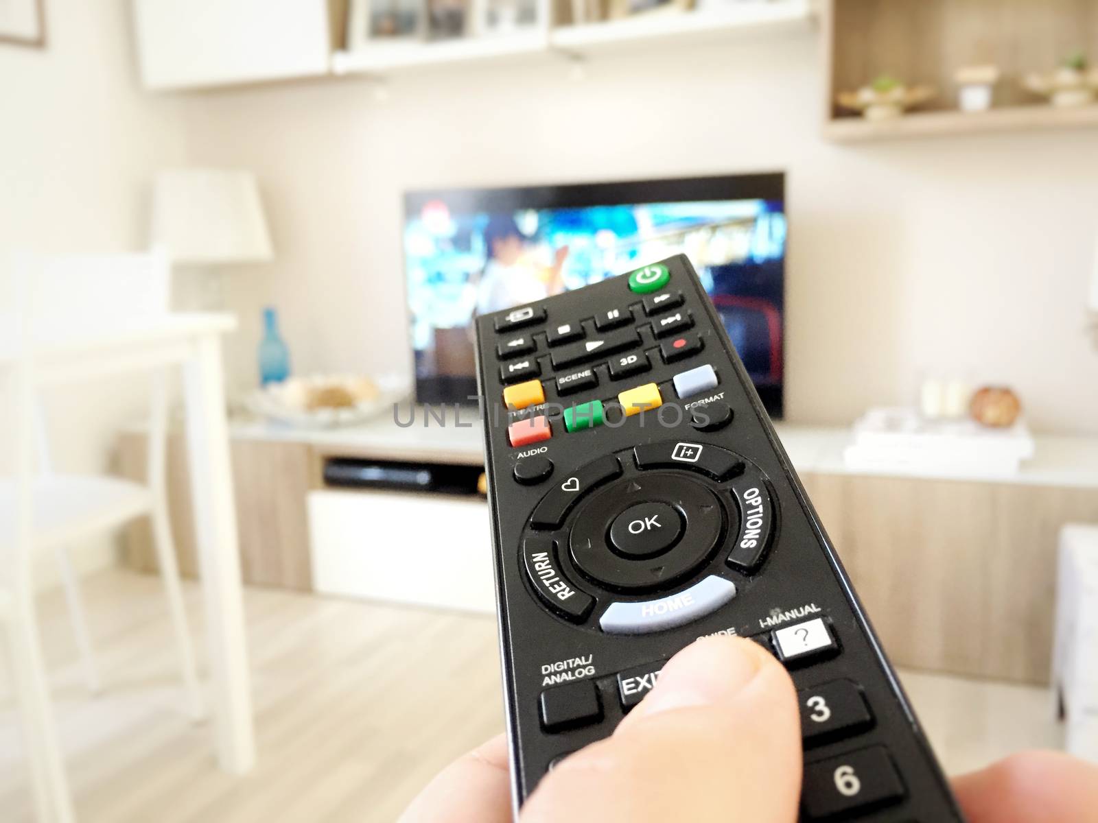 Male hand holding TV remote control. Point of view shot