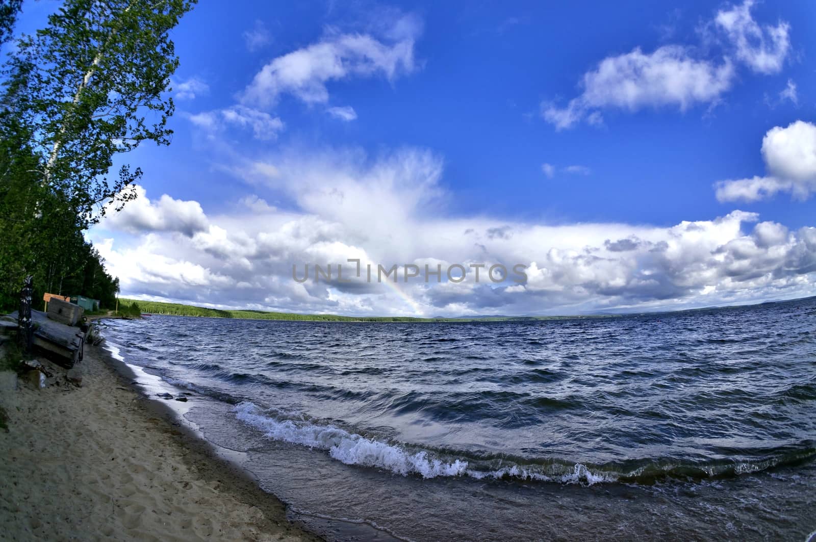 wave rages and runs on the shore of the lake on a bright Sunny day, shooting from the bottom point