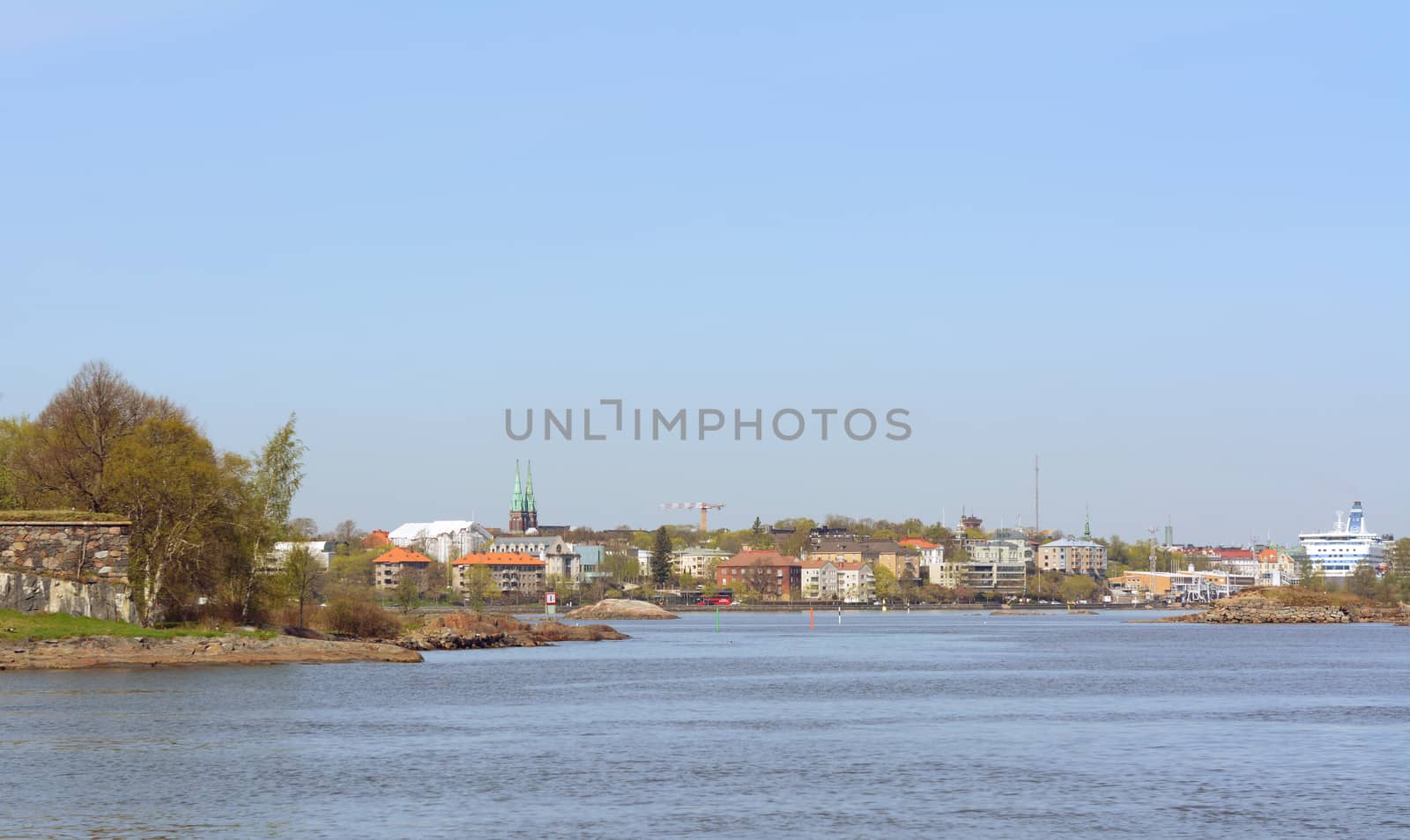 Shoreline of Suomenlinna, a UNESCO World Heritage site in Finland, lined with houses, buildings and trees