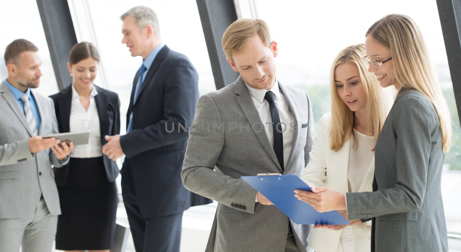 Business people talking at meeting in office near window