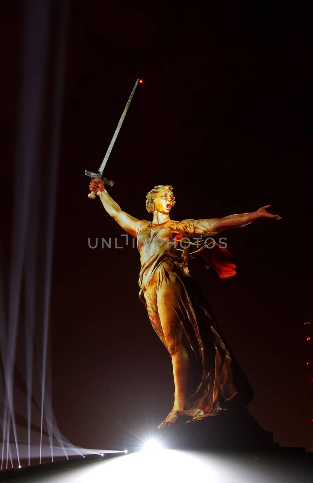 Sculpture the Motherland on Mamayev Kurgan in gold light during the show Light of the Great Victory 2018 of year