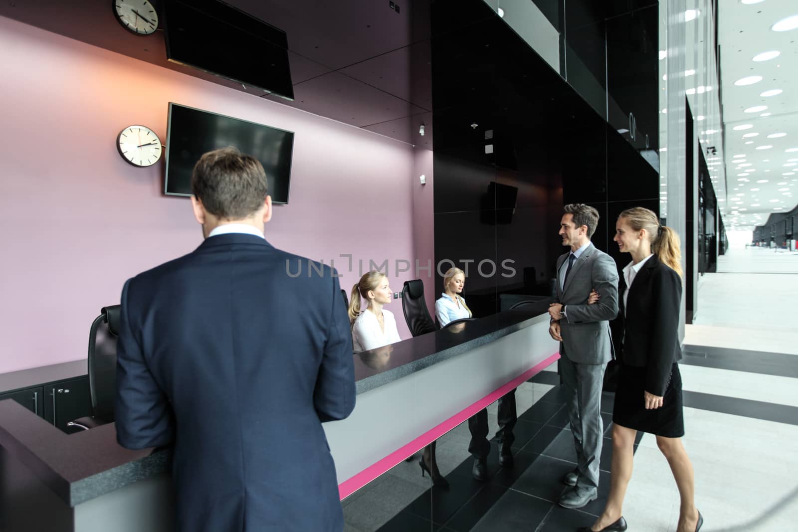 Business people at front desk by ALotOfPeople
