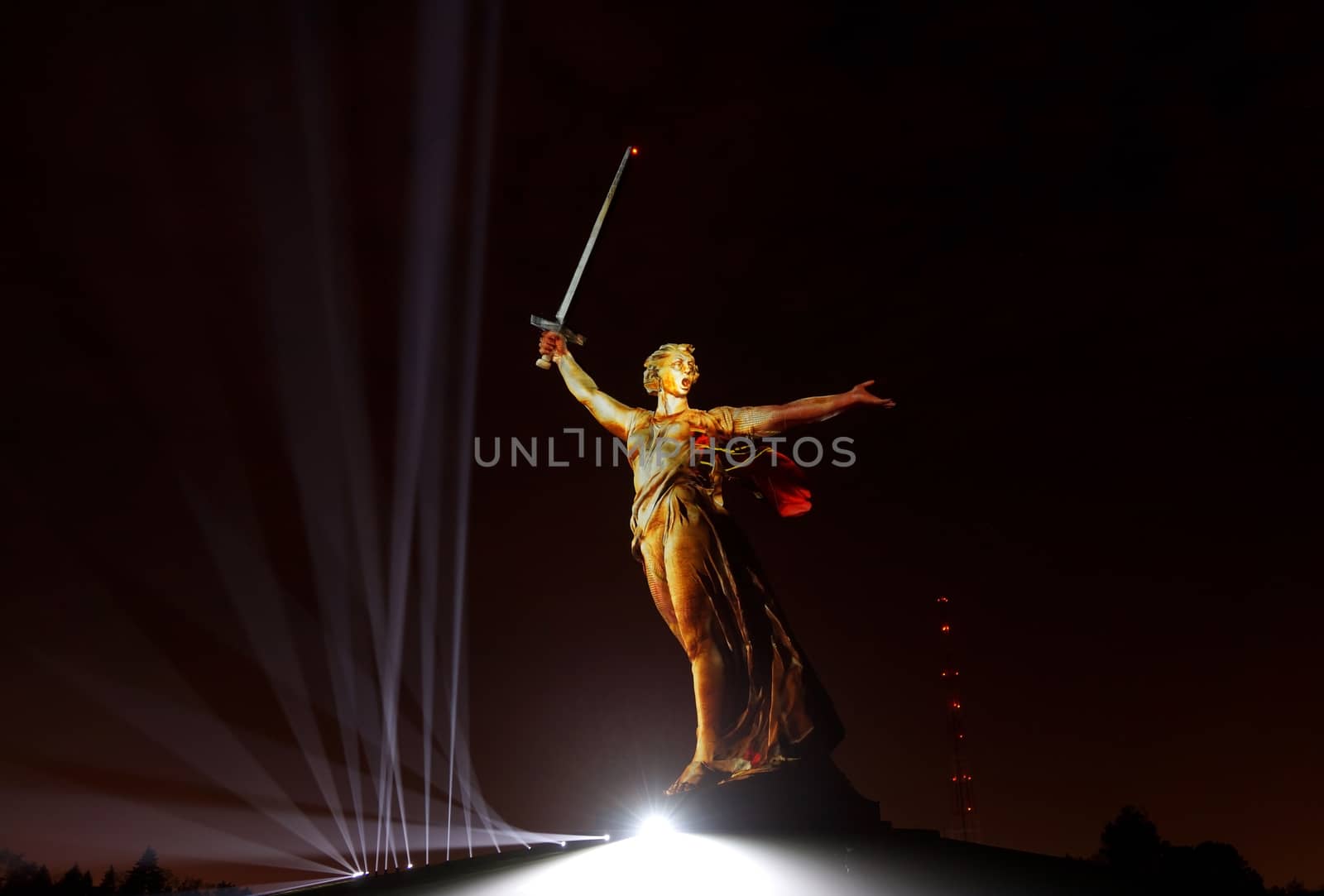 Sculpture the Motherland on Mamayev Kurgan in gold light during the show Light of the Great Victory 2018 of year                               