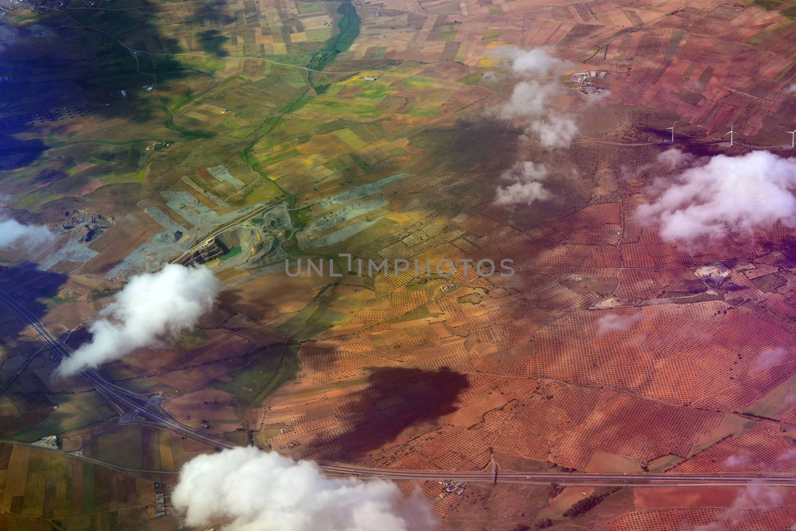 Dramatic aerial view from plane of patchwork farmland and houses