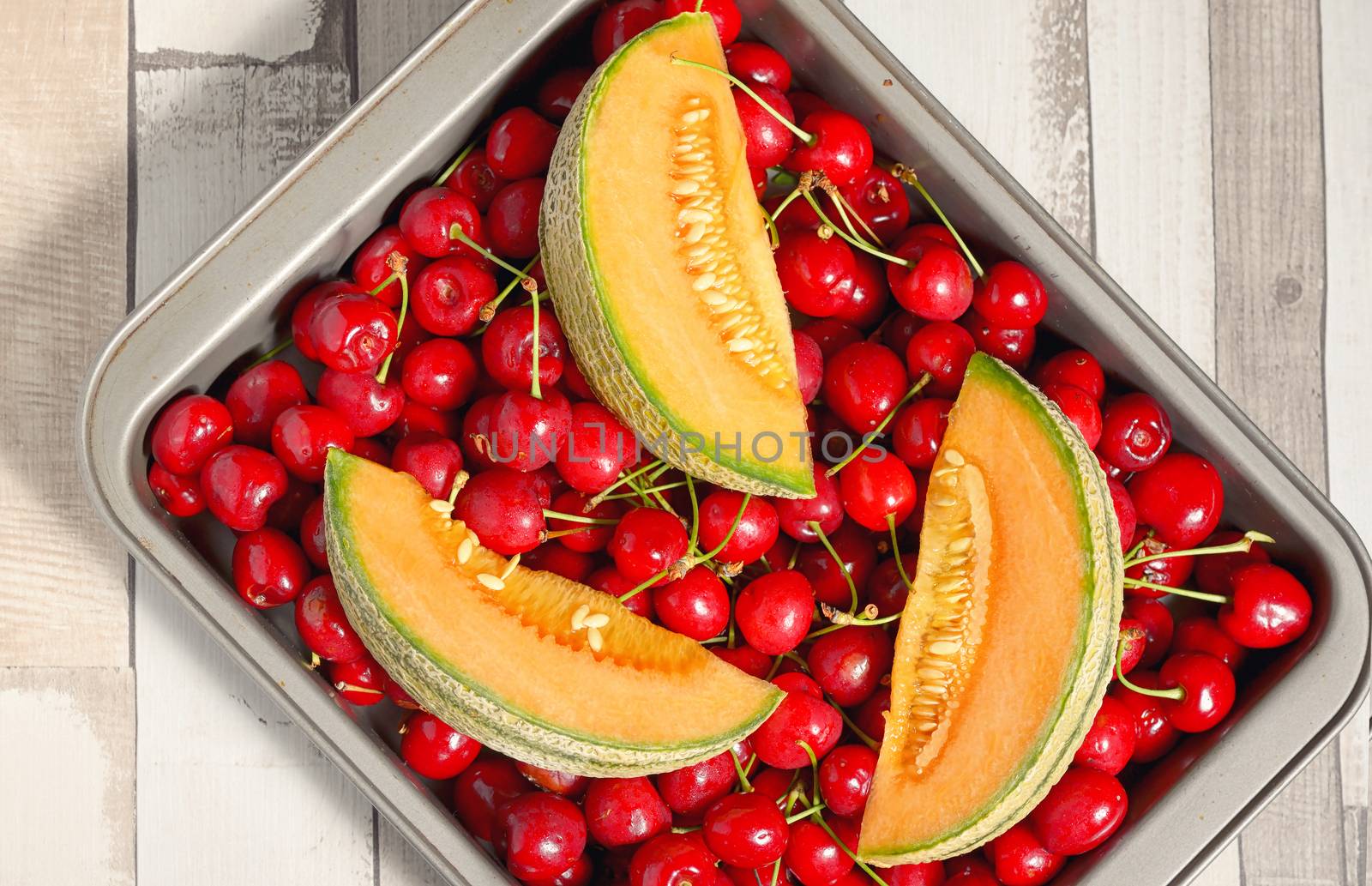 Honeydew melon and cherry fruits on wooden table