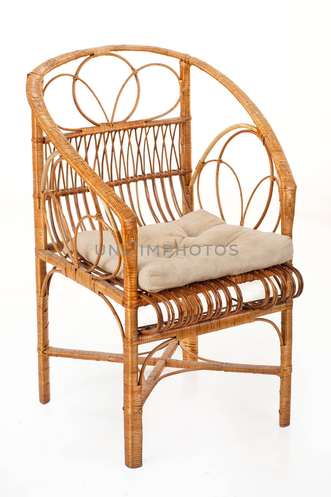 Wicker armchair with a pillow on an isolated studio background