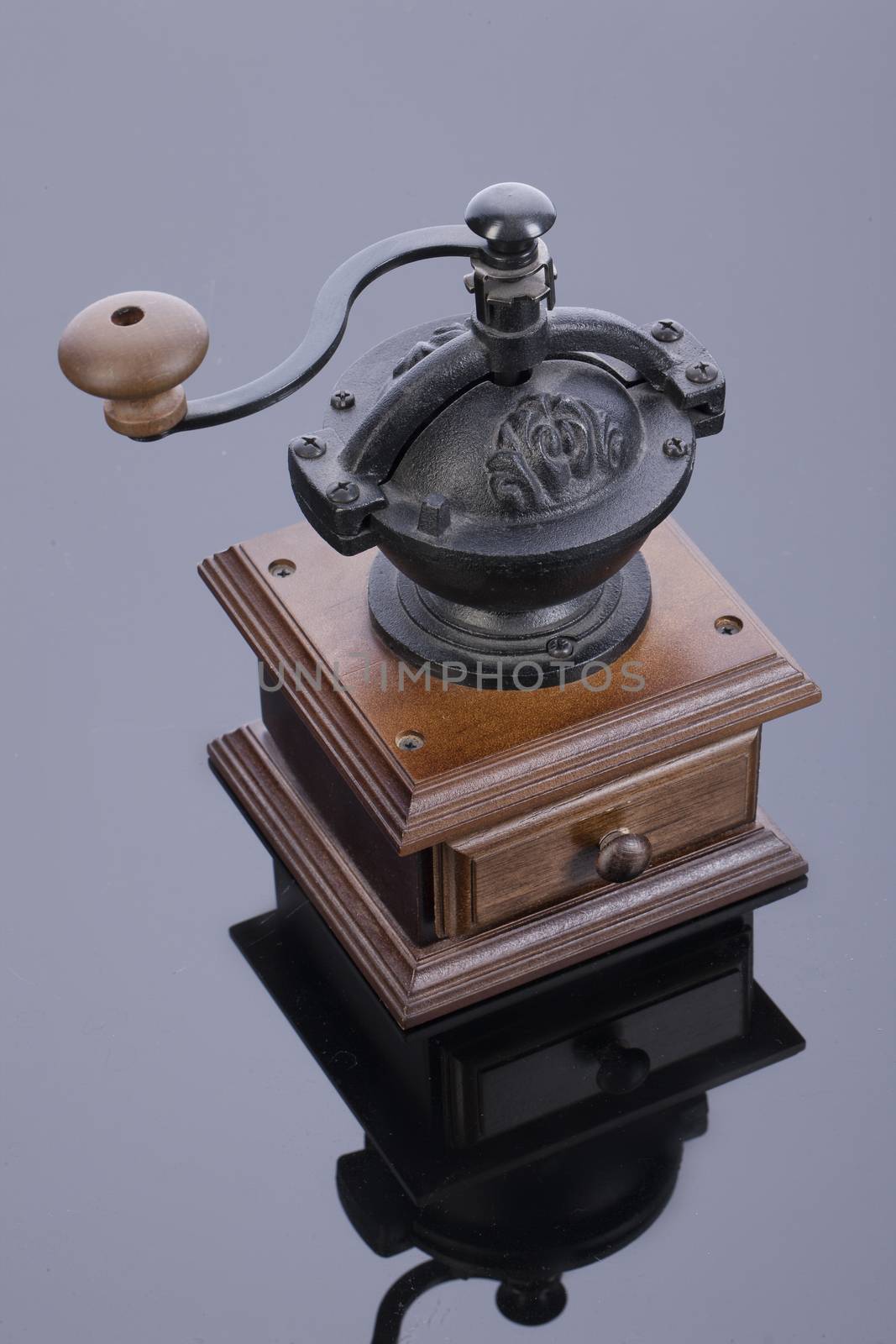 Old coffee mill on a glass studio background