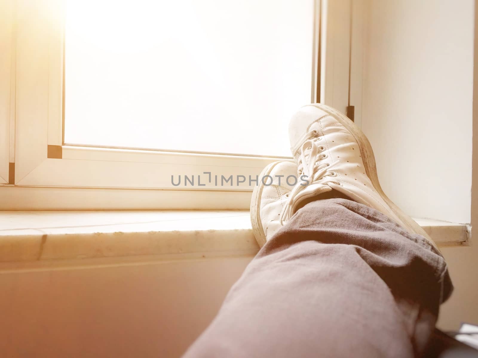 Feet crossed in front of a closed window by rarrarorro