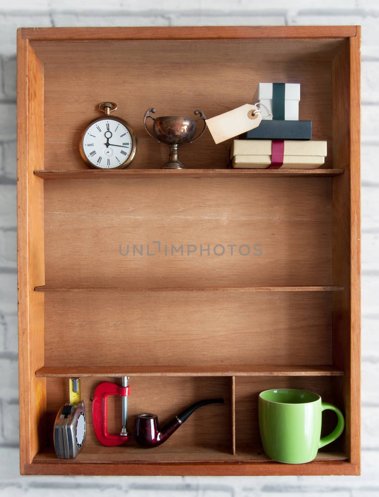 Fathers day gift with blank gift label inside a shelf with various objects including tools and coffee cup