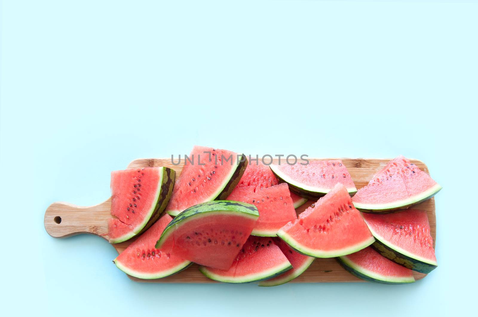 Fresh watermelon slices on wooden chopping board