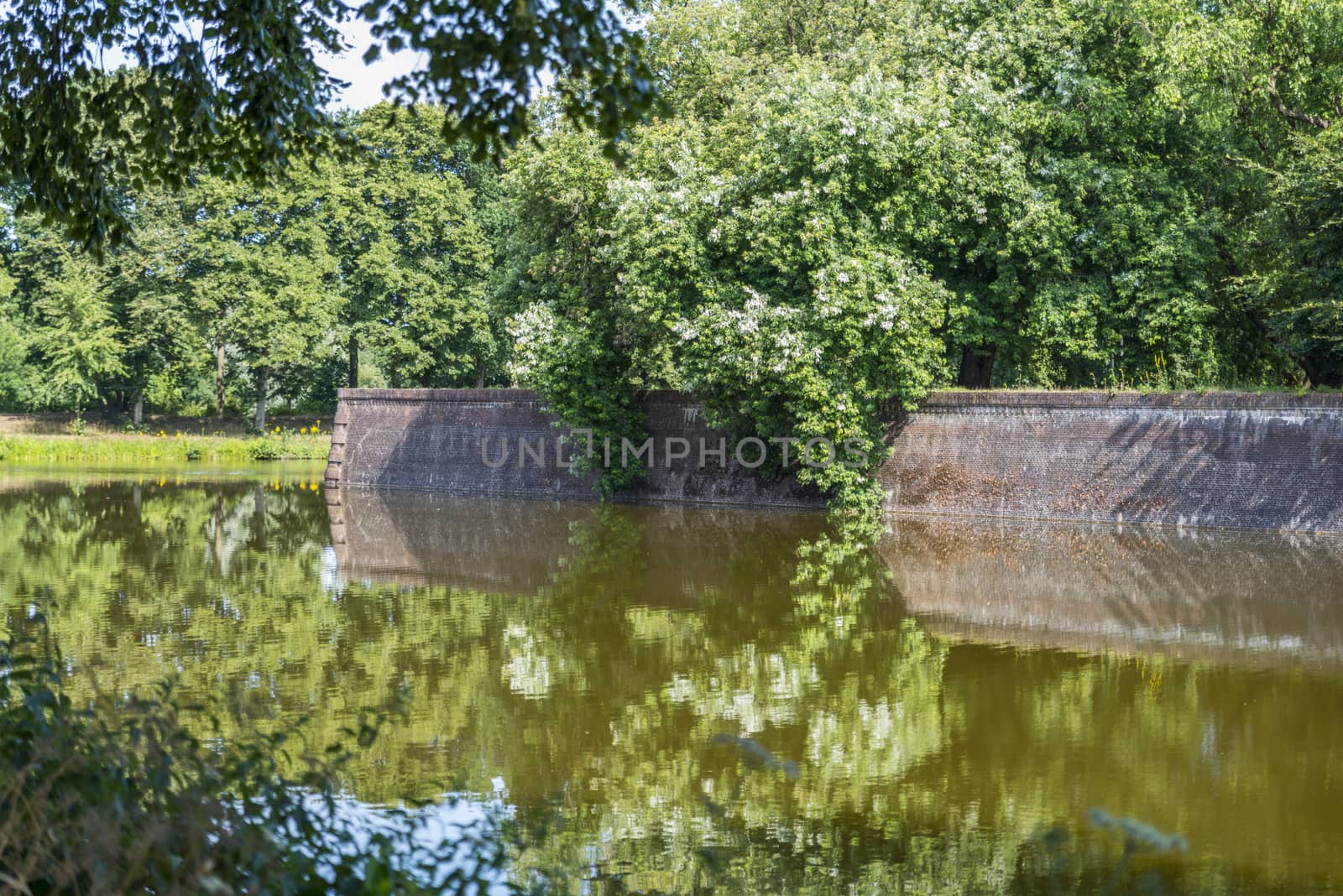 Bastion Oranje the old fortified town of Naarden with reflection of flowers in the water, North Holland, Netherlands, Dutch fortress in water surrounded Naarden Vesting