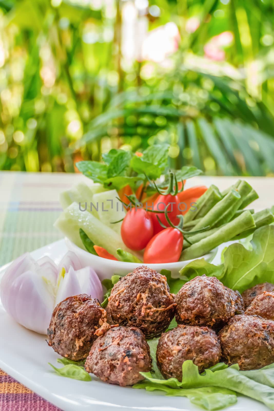 Deep fried spicy minced pork served with fresh vegetables on white plate