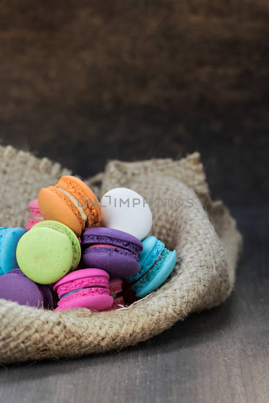 colorful of macarons on a sack over wooden table