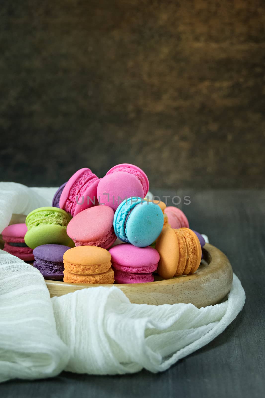 colorful of macarons on plate over wooden table