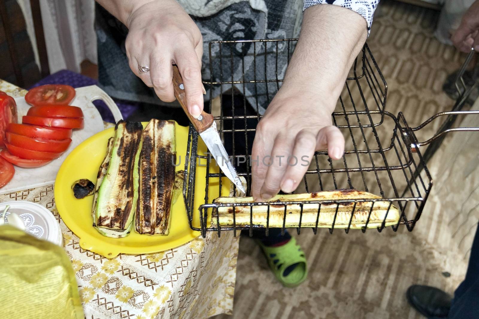 grilled zucchini spread on a plate, visible hands of the cook, cooking for the picnic
