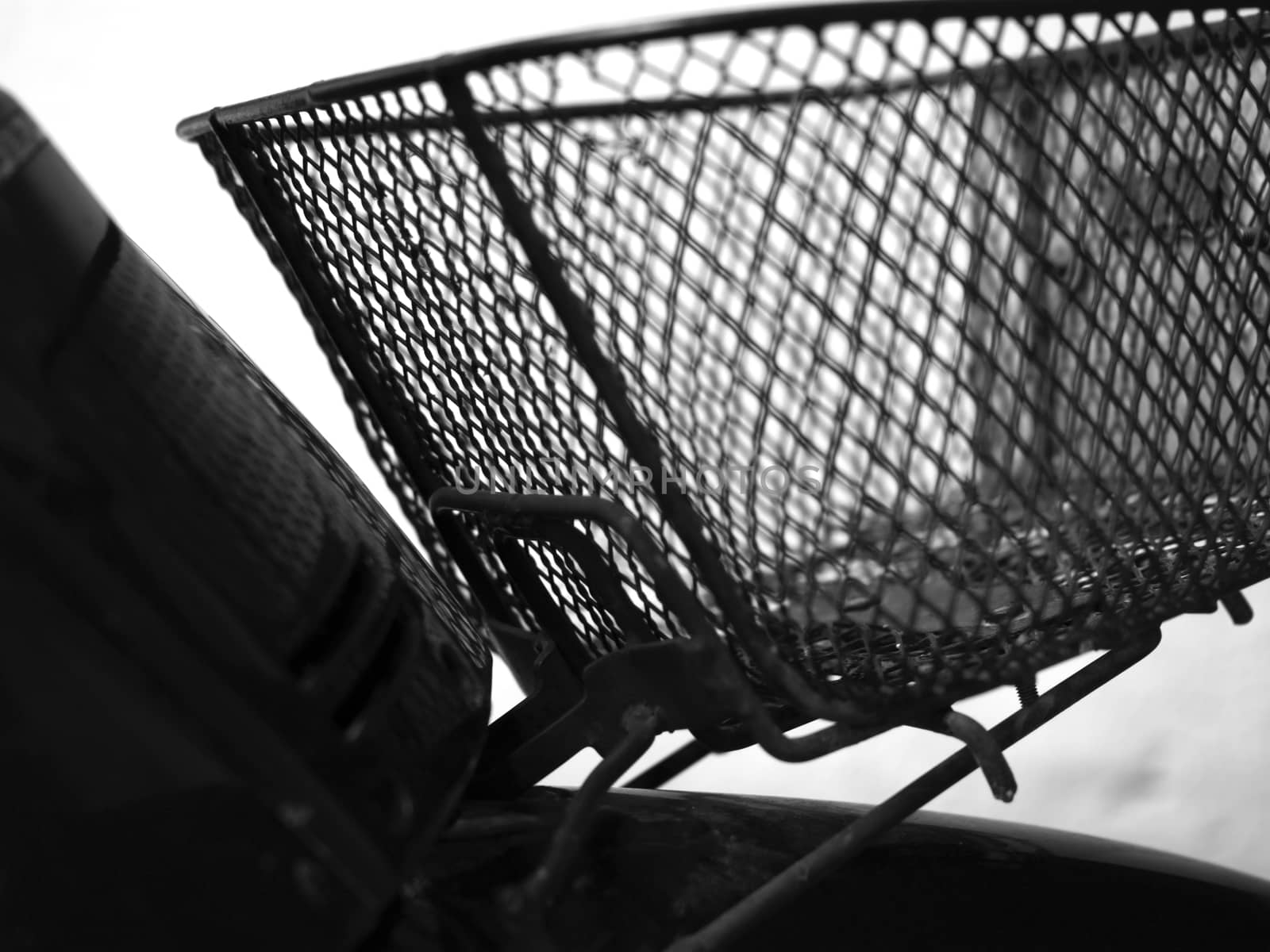 BLACK AND WHITE PHOTO OF BLURRY SHOT OF MOTORCYCLE FRONT METAL BASKET