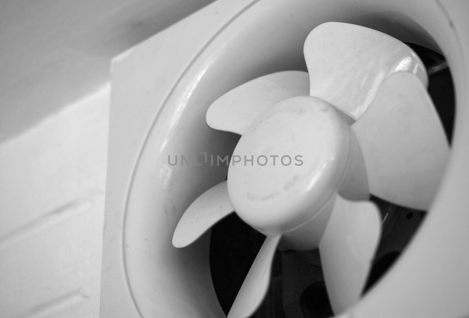BLACK AND WHITE PHOTO OF EXHAUST FAN MOUNTED ON WALL
