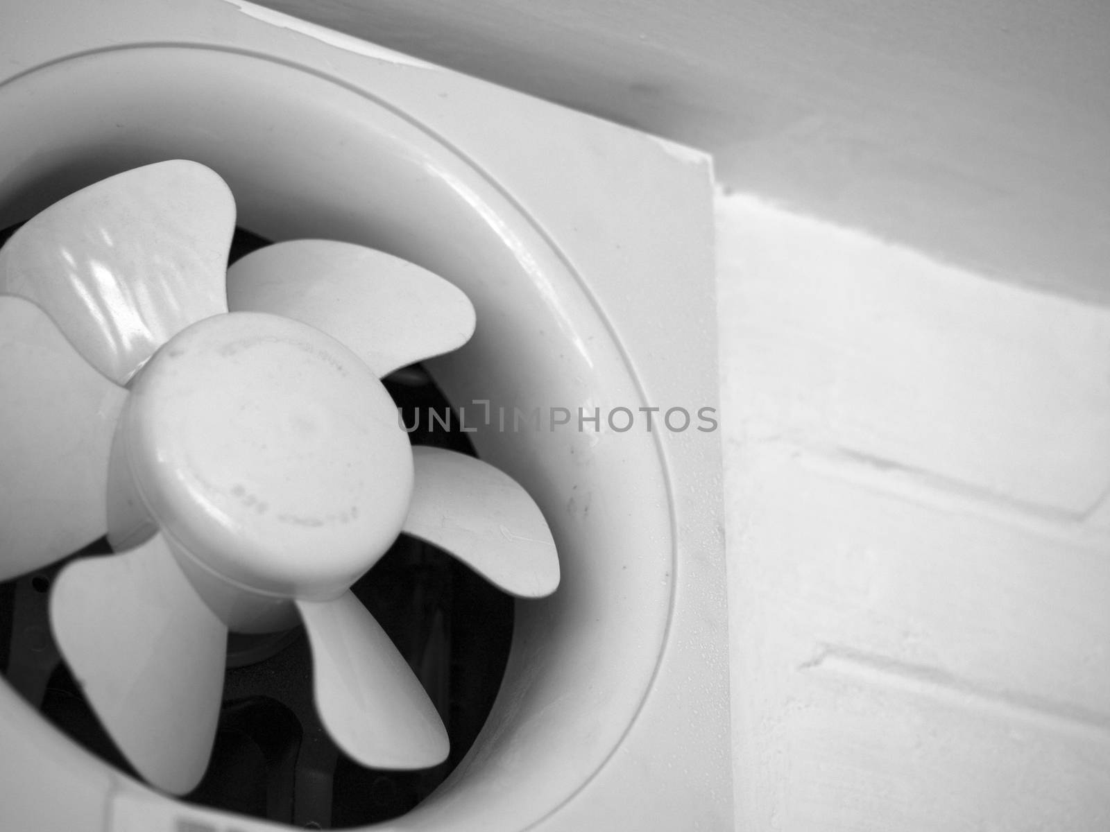 BLACK AND WHITE PHOTO OF EXHAUST FAN MOUNTED ON WALL