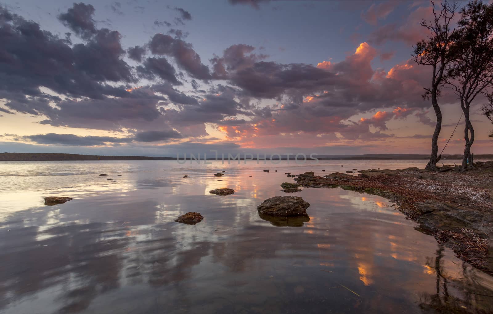 Tranquil sunset on the basin estuary with sunset reflections, the sound of gentle ripples and fish jumping