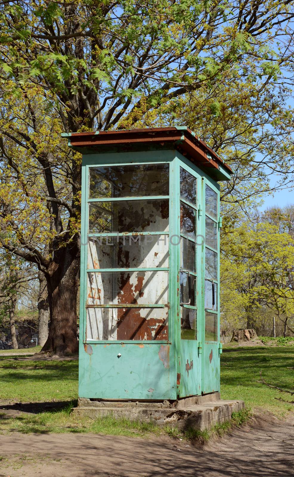 Weathered and rusted disused phone booth with peeling pale green paint on Suomenlinna island, Finland