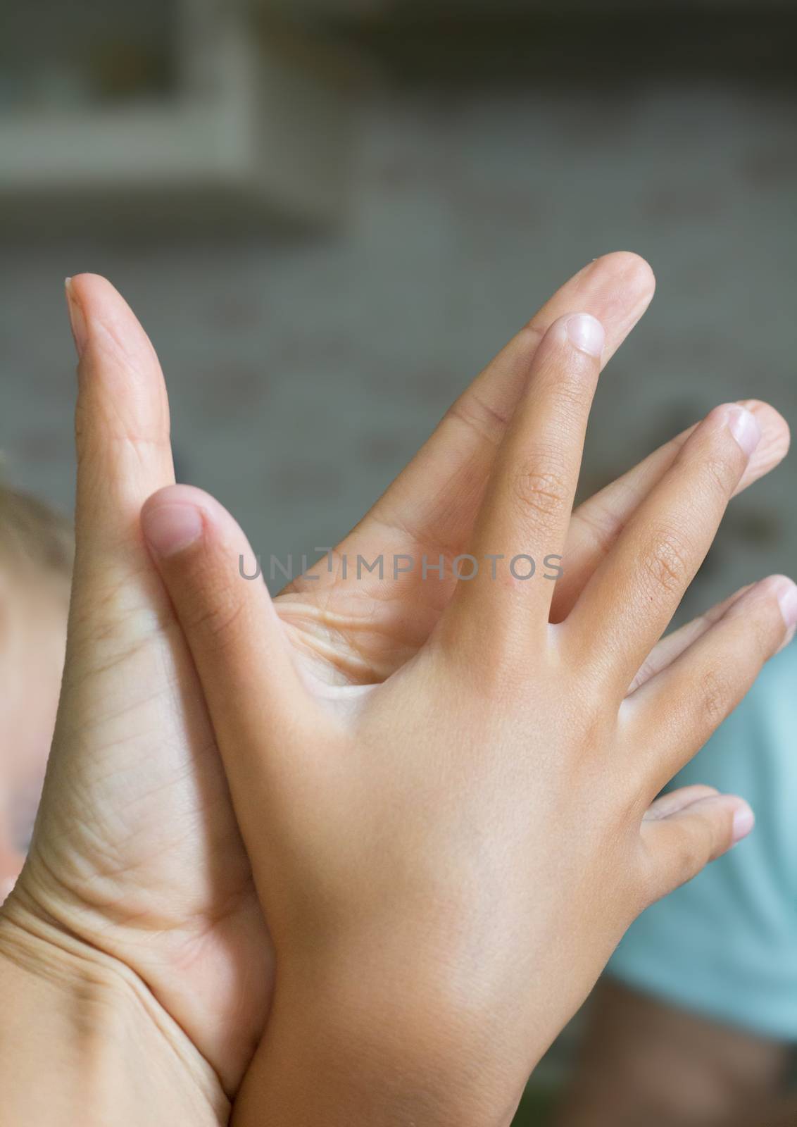 Two human hands of adult and child holding together showing love and careness