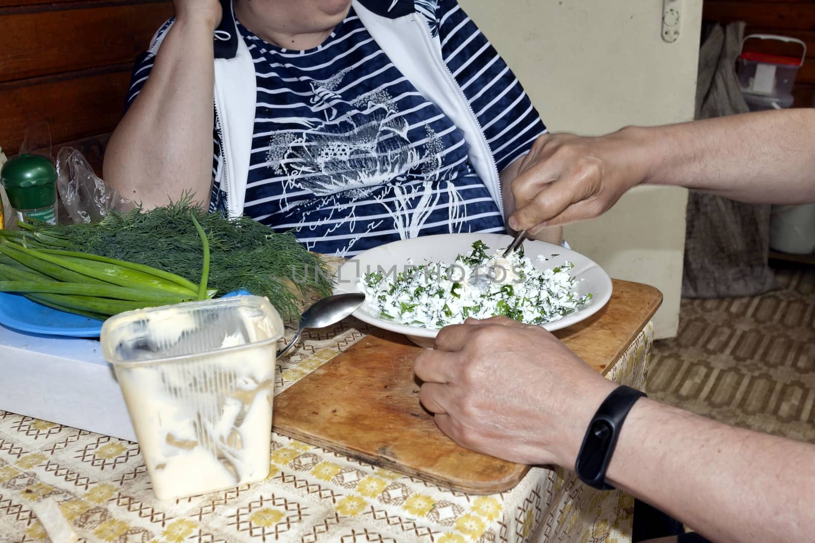addition of sour cream in the cheese with greens and mixing, see the human hand