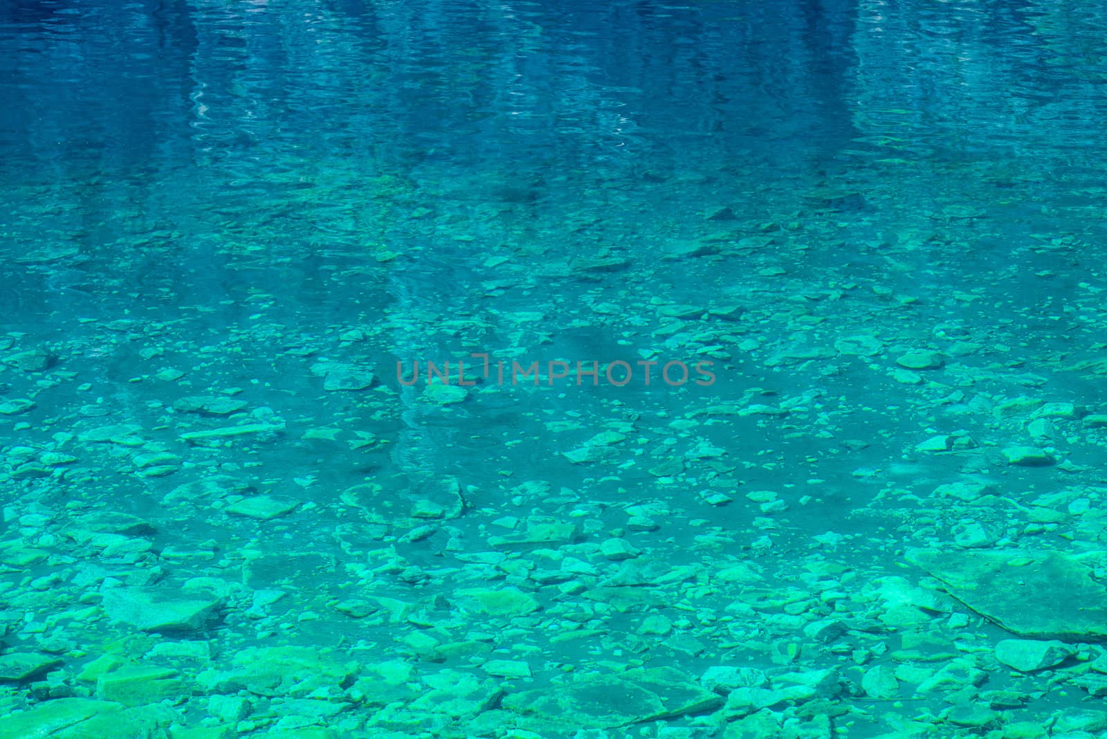 transparent water of a mountain lake, a view of the rocky bottom