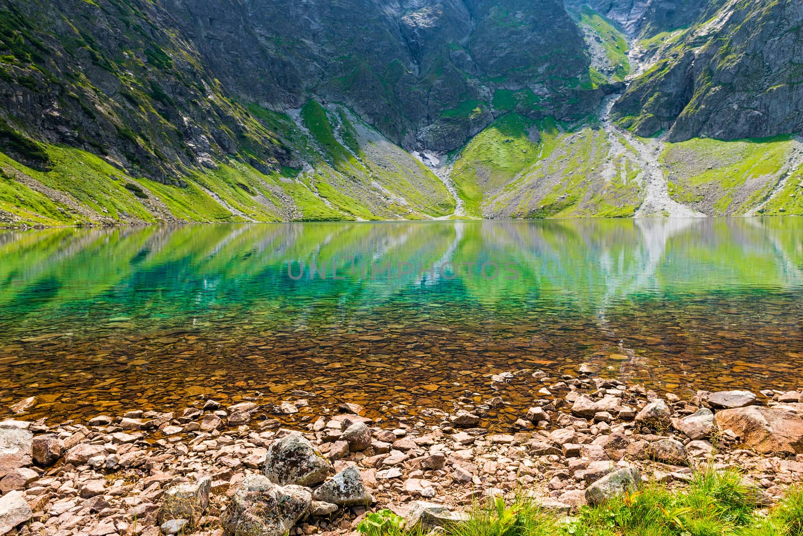 clean mountain cold lake Czarny Staw close-up on a sunny day