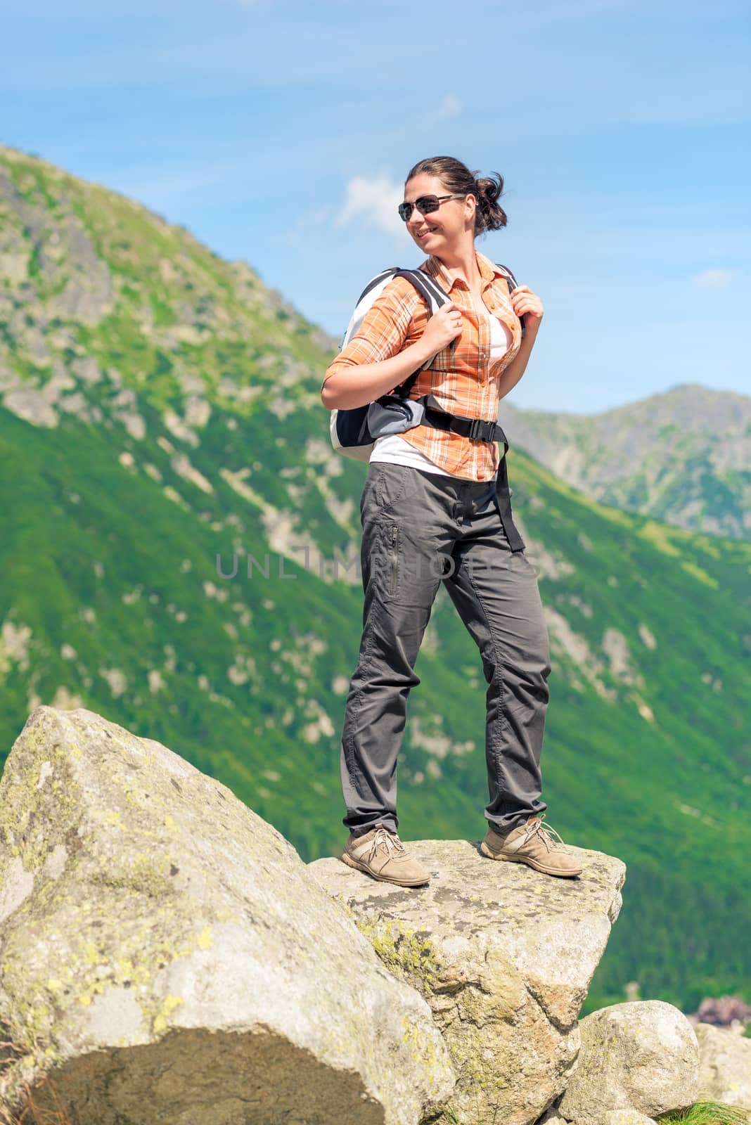 portrait of a tourist with a backpack high in the mountains in a hike