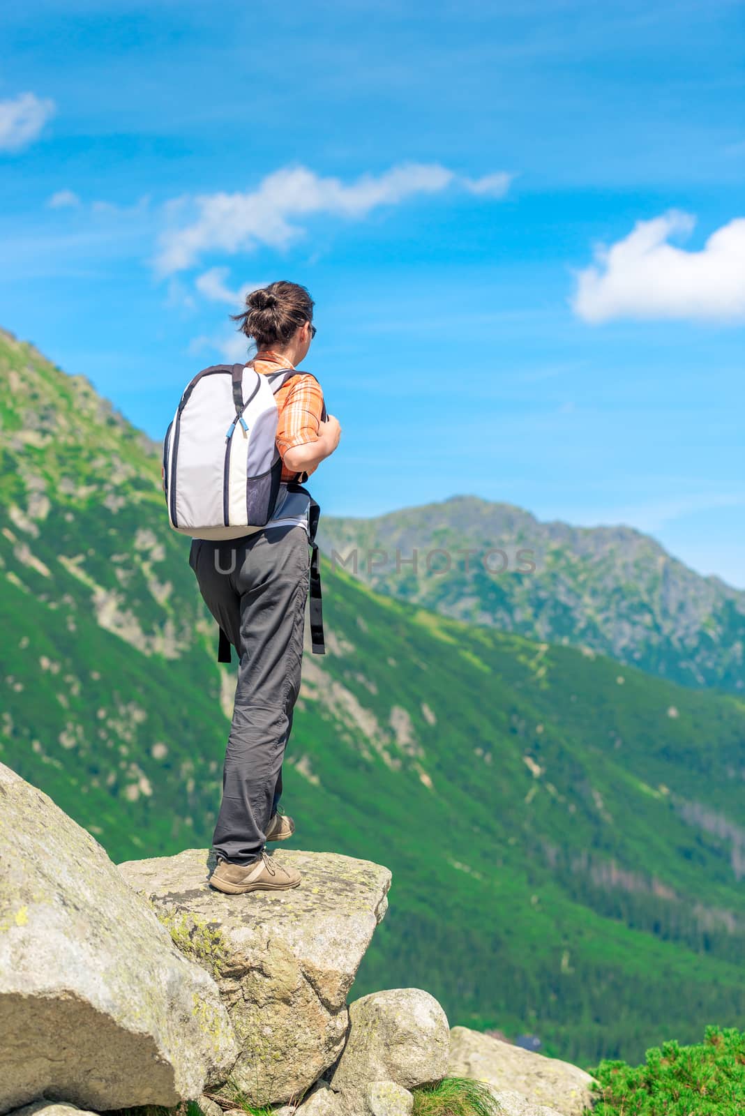 view from the back of a tourist with a backpack in the mountains by kosmsos111