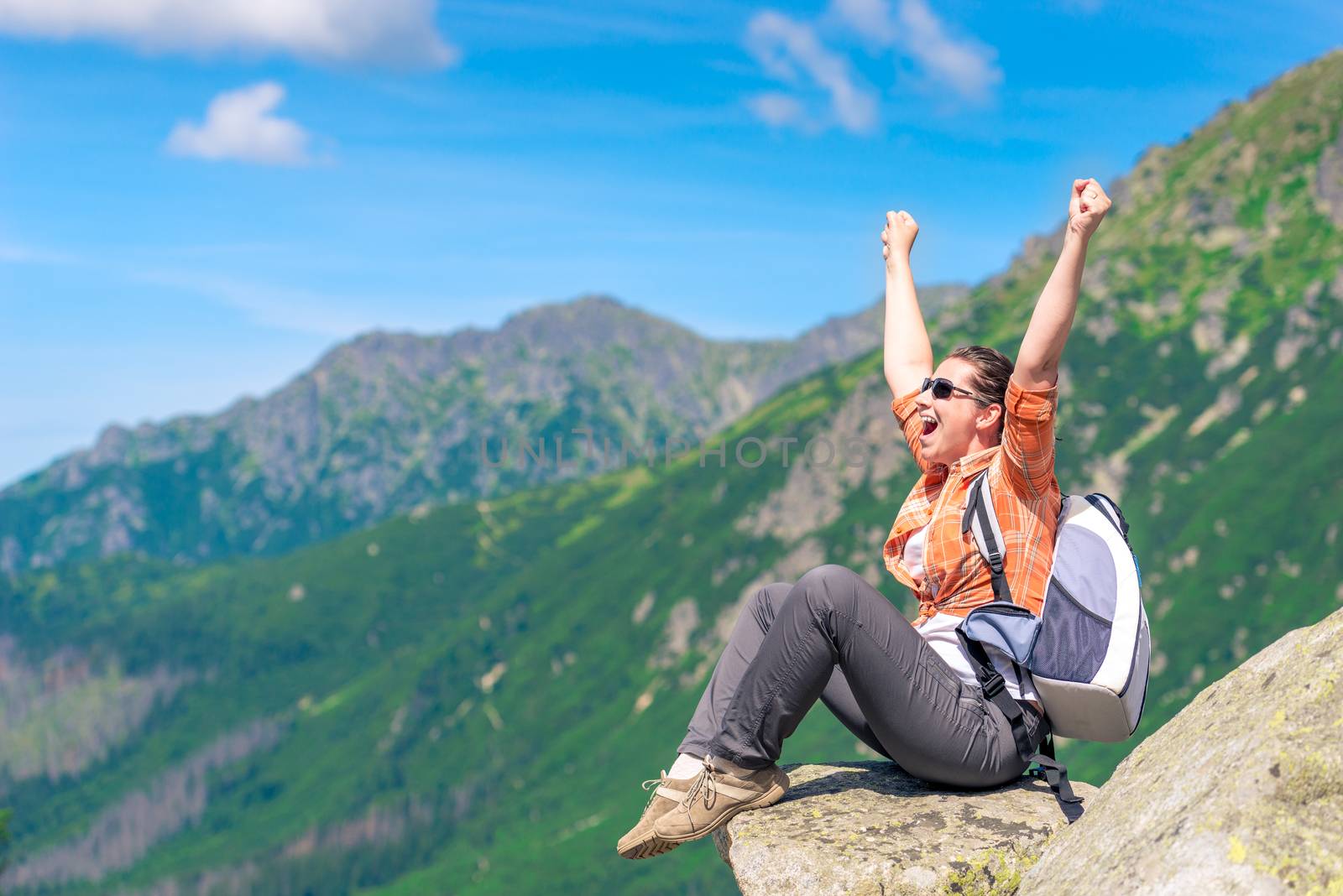 A successful tourist who sits on a mountain and enjoys freedom