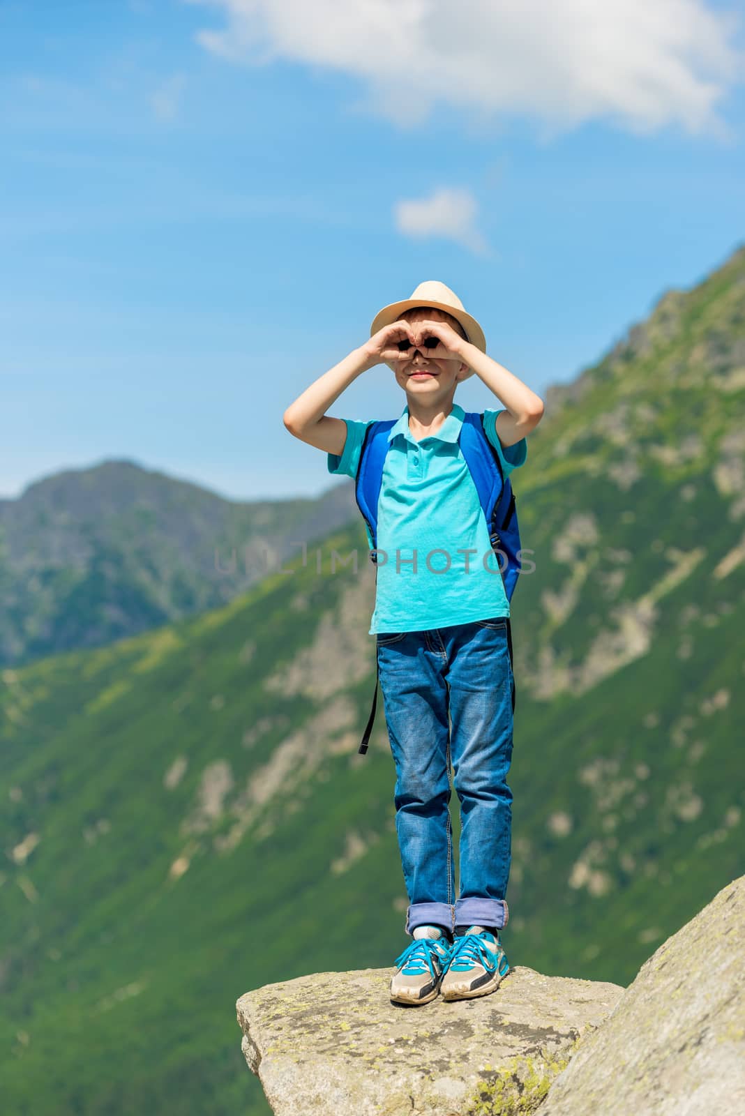 traveler boy looks at beautiful mountains, stands on stone by kosmsos111