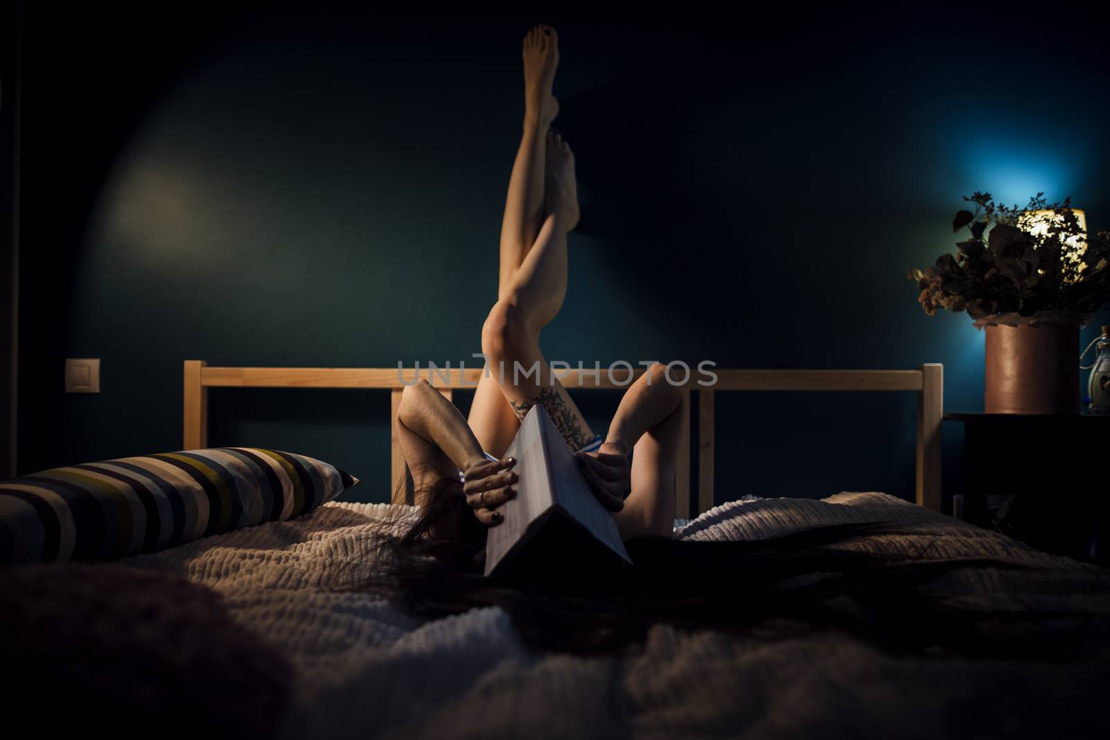 Young attractive woman on a bed at night