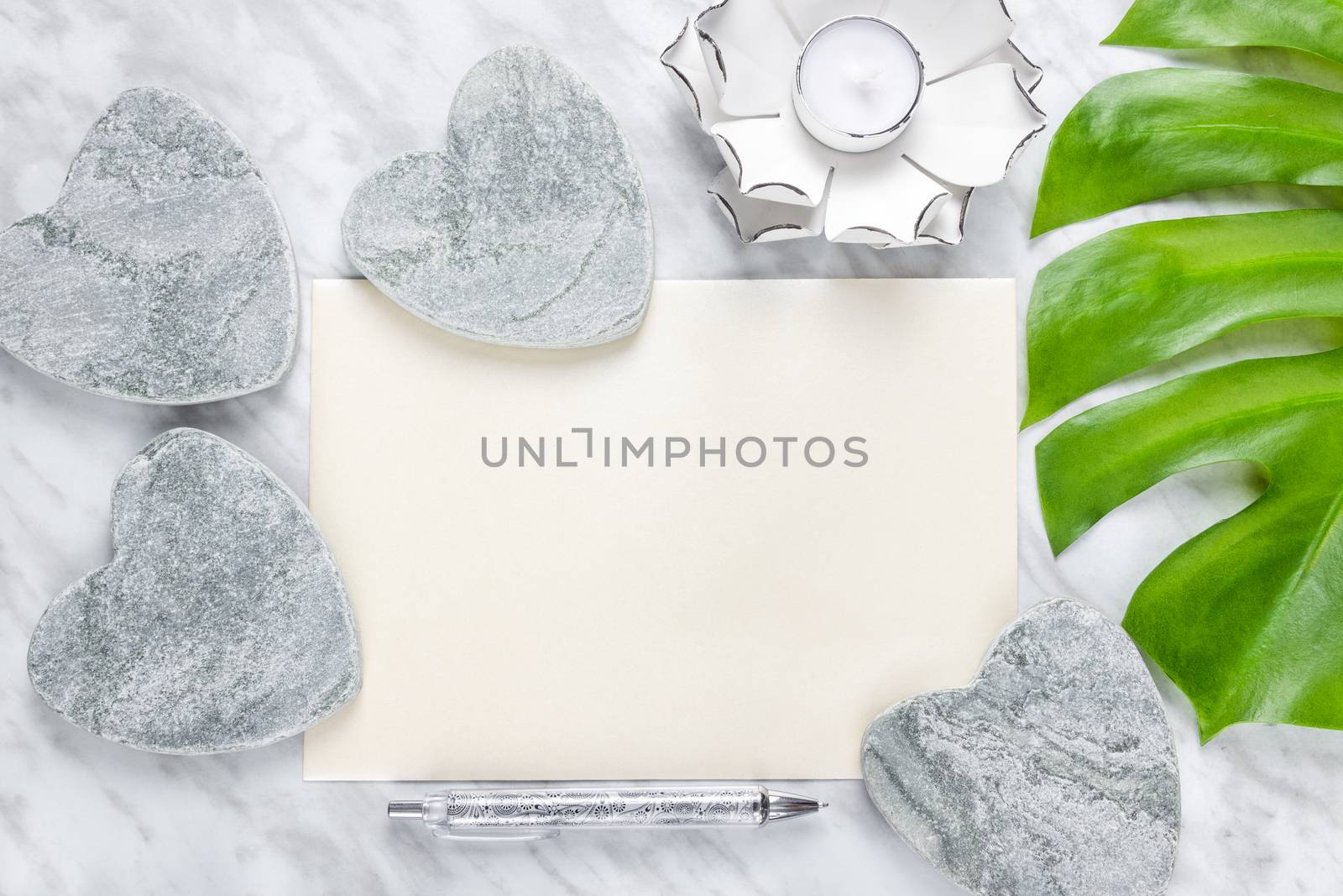 Stylish home decor and blank sheet of paper with copy space. Flat lay composition on marble background.
