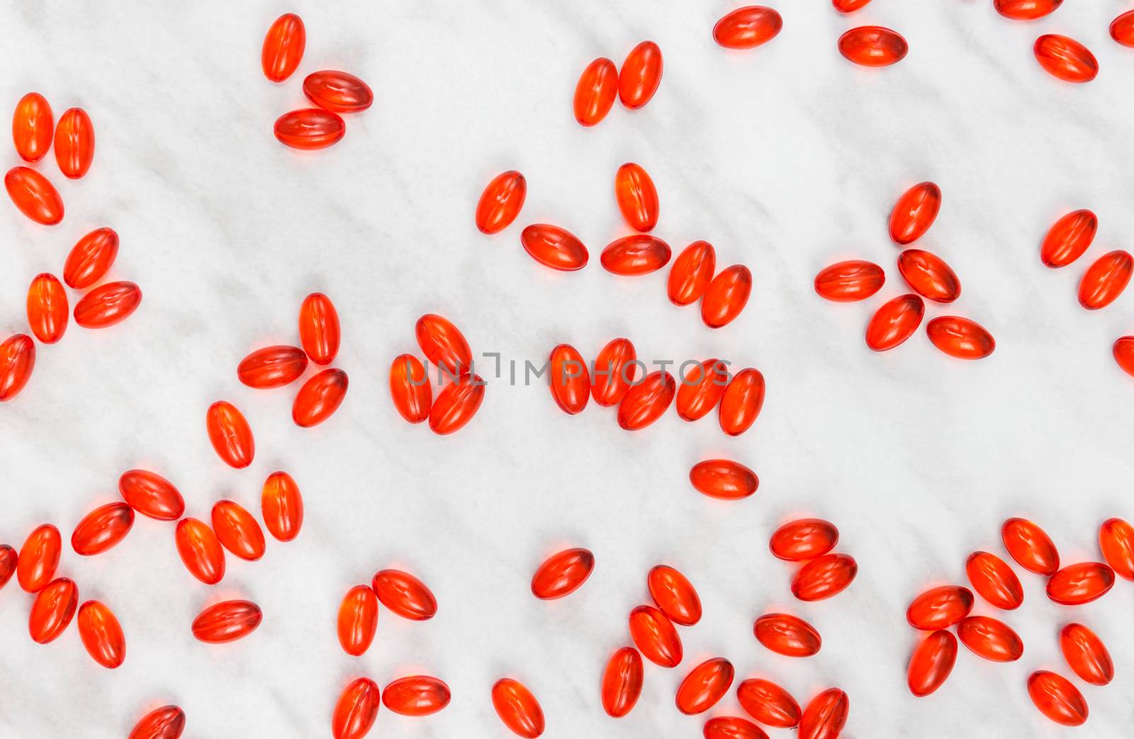 Red shiny pills on marble background by anikasalsera
