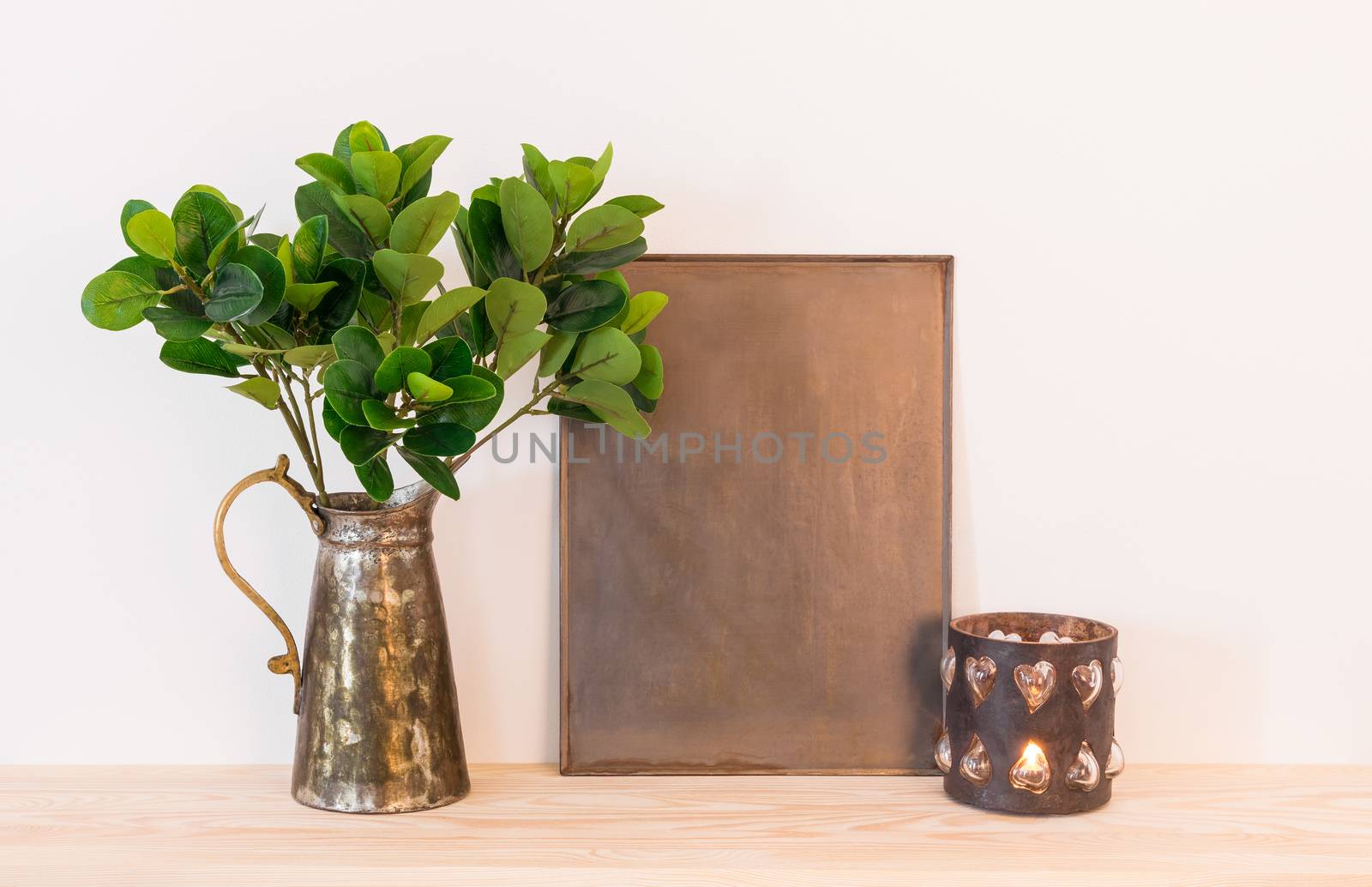 Vintage style home decor composition. Metal frame with copy space, ficus in antique jar and candle.