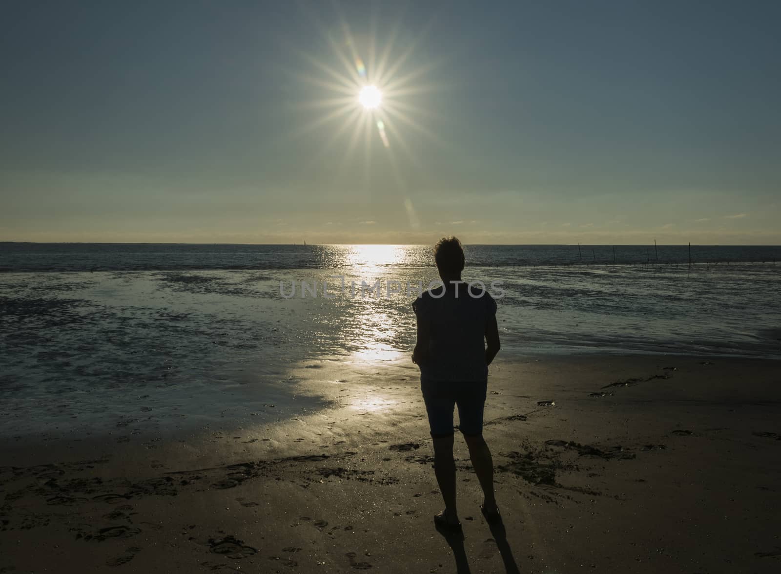 Rockanje,Holland,13-07-2018:Woman standing at the bach during sunset looking at the sea in Rockanje,Rockanje is a famous beach spot in Holland