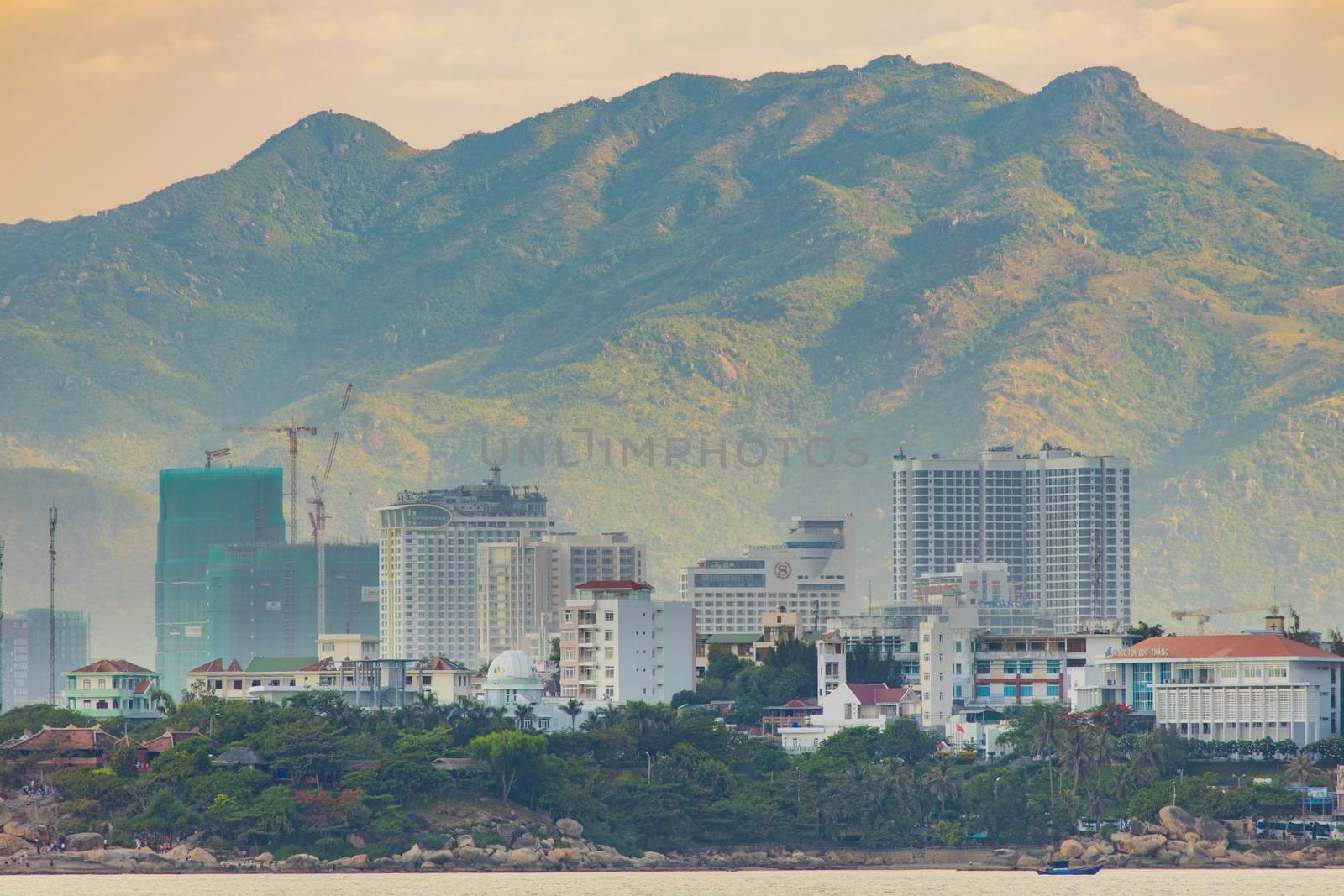 Nha Trang, Vietnam, Asia July 3 2018. Vietnamese holiday resort beach front skyline scene with skyscraper hotels and apartment blocks. With the rugged mountain landscape in the background.