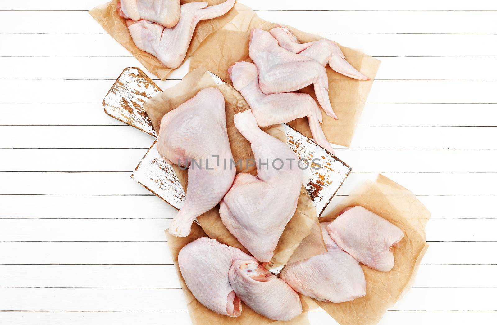Raw chicken meat on cutting board on white wooden background. Top view by xamtiw
