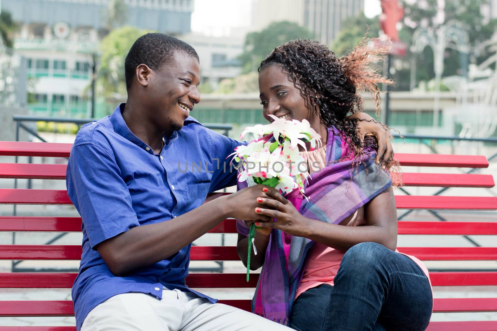 This young man gives a flower to a young woman he looks into her eyes with a beautiful smile