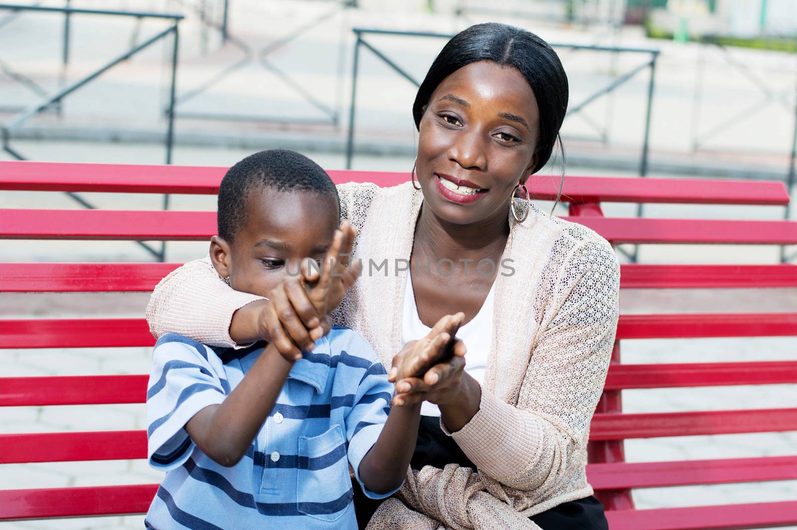 young woman grabs the hand of her child to applaud to him.