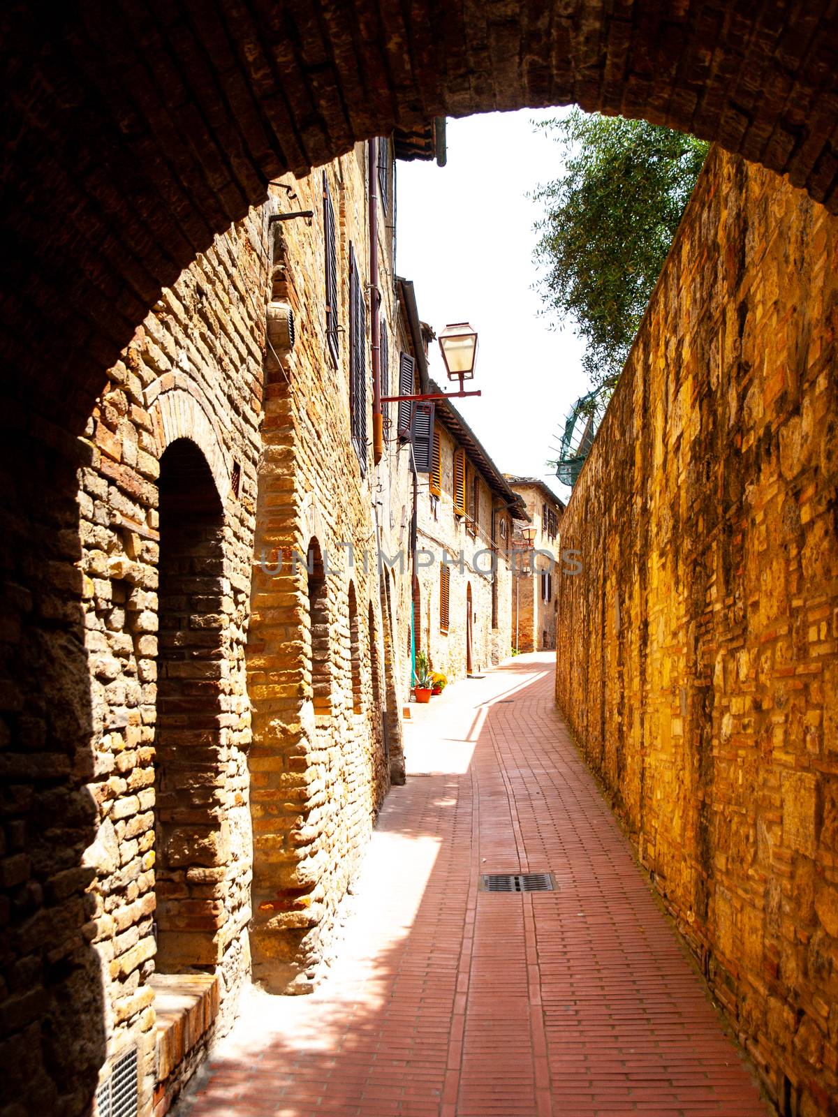 Picturesque medieval narrow street of San Gimignano old town, Tuscany, Italy.