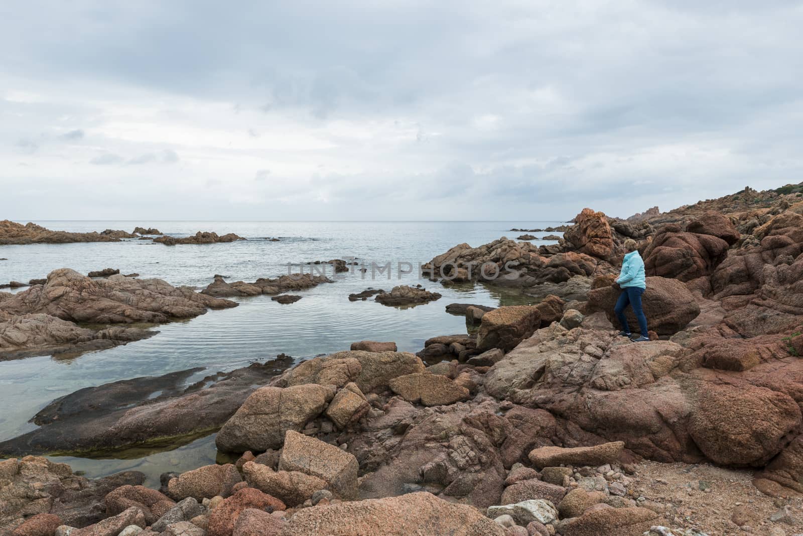 woman on the rocks of isola rossa sardinia by compuinfoto