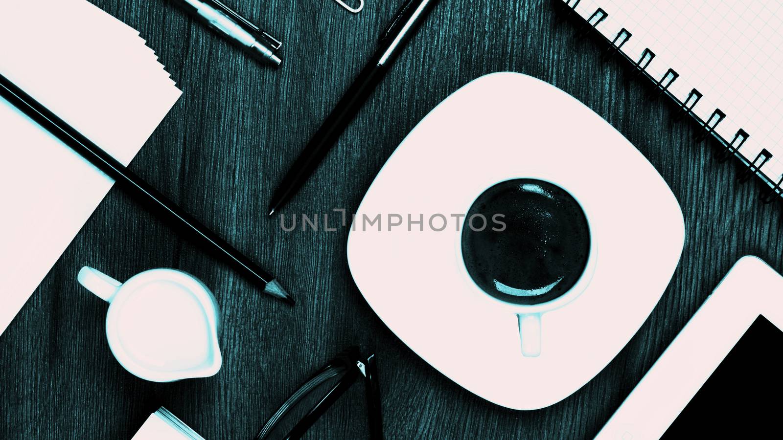 Coffee Break Concept with Stationery Items, Coffee Cup with Milk Jug, Digital Tablet and Greens Eyeglasses closeup on Wooden background. Turquoise toned