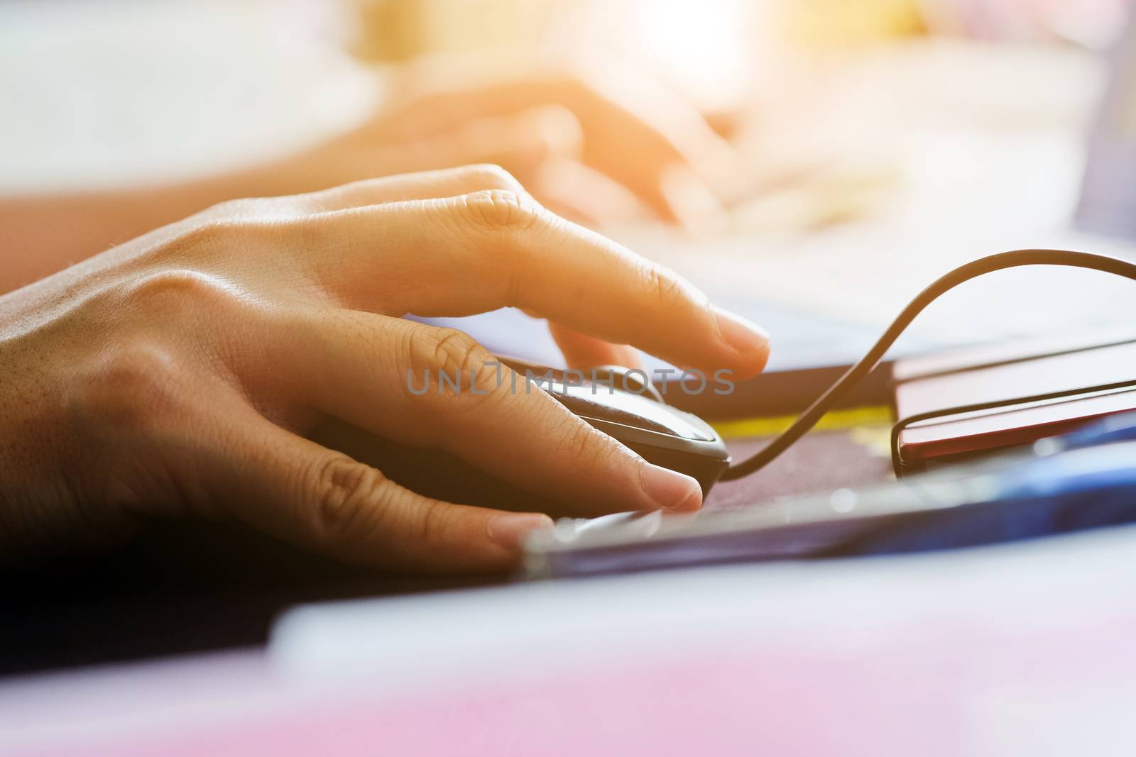 Close-up of female hands using laptop computer, working on laptop with flare light background. Searching Internet ,Businesswoman working at home office